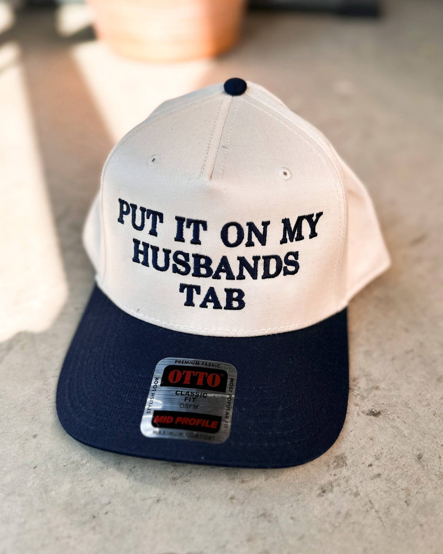 Put It On My Husbands Tab Trucker Hat